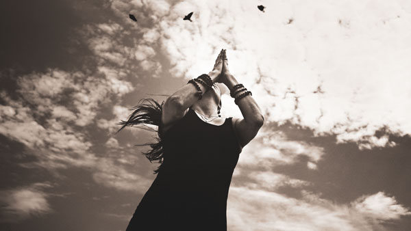 Michele Fisher in Anjali Mudra with birds flying overhead